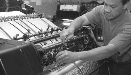 A press operator adjusting one of our braille presses