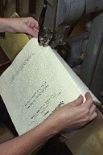 A member of our production team stitching a braille volume