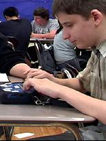 Image of a student using a braille note taker in the classroom.