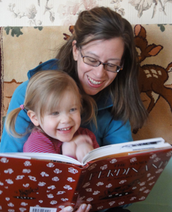 Picture of adult & small child reading braille book