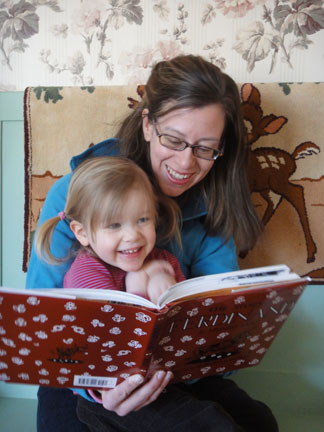 Mother and baby read a print/braille book