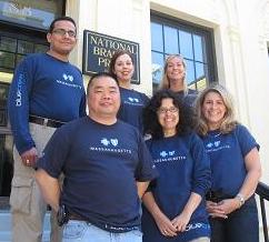 Picture of Blue Cross Blue Shield volunteers standing on the front steps of National Braille Press.