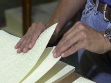 A worker collates braille pages into a single volume