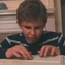 Image of young boy reading a braille version of Harry Potter