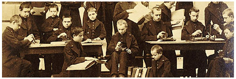 A vintage photo of blind students using Louis Braille's raphigraph and reading braille books.