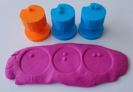 sample of braille stampers shows a b c stamped into play-doh