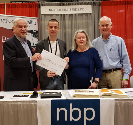 A photo of Committee Member Paul Parravano, winner Fedor Belomoev, Committee Member Judy Dixon, and President Brian MacDonald awarding the Prize to 4Blind.