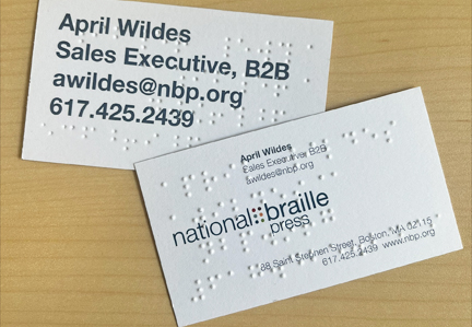 Hand holding a braille embossed NBP business card.