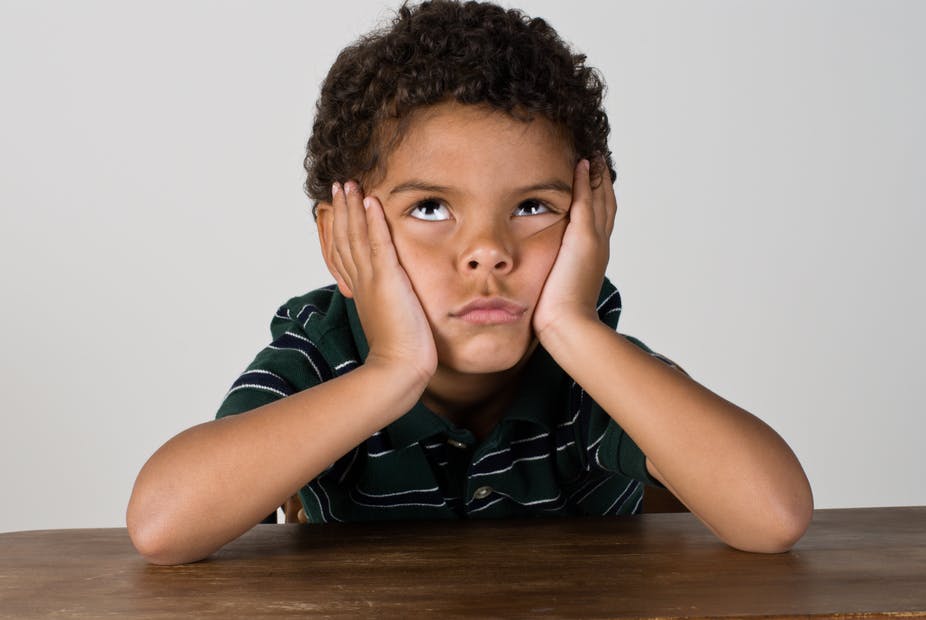 Boy rolling his eyes, head in his hands.