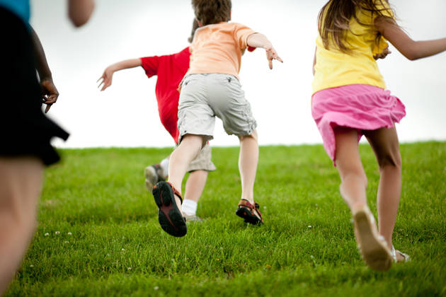 kids run up a hill at recess