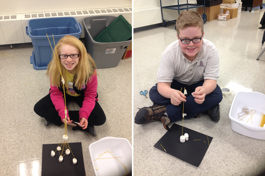 Two students show off their towers