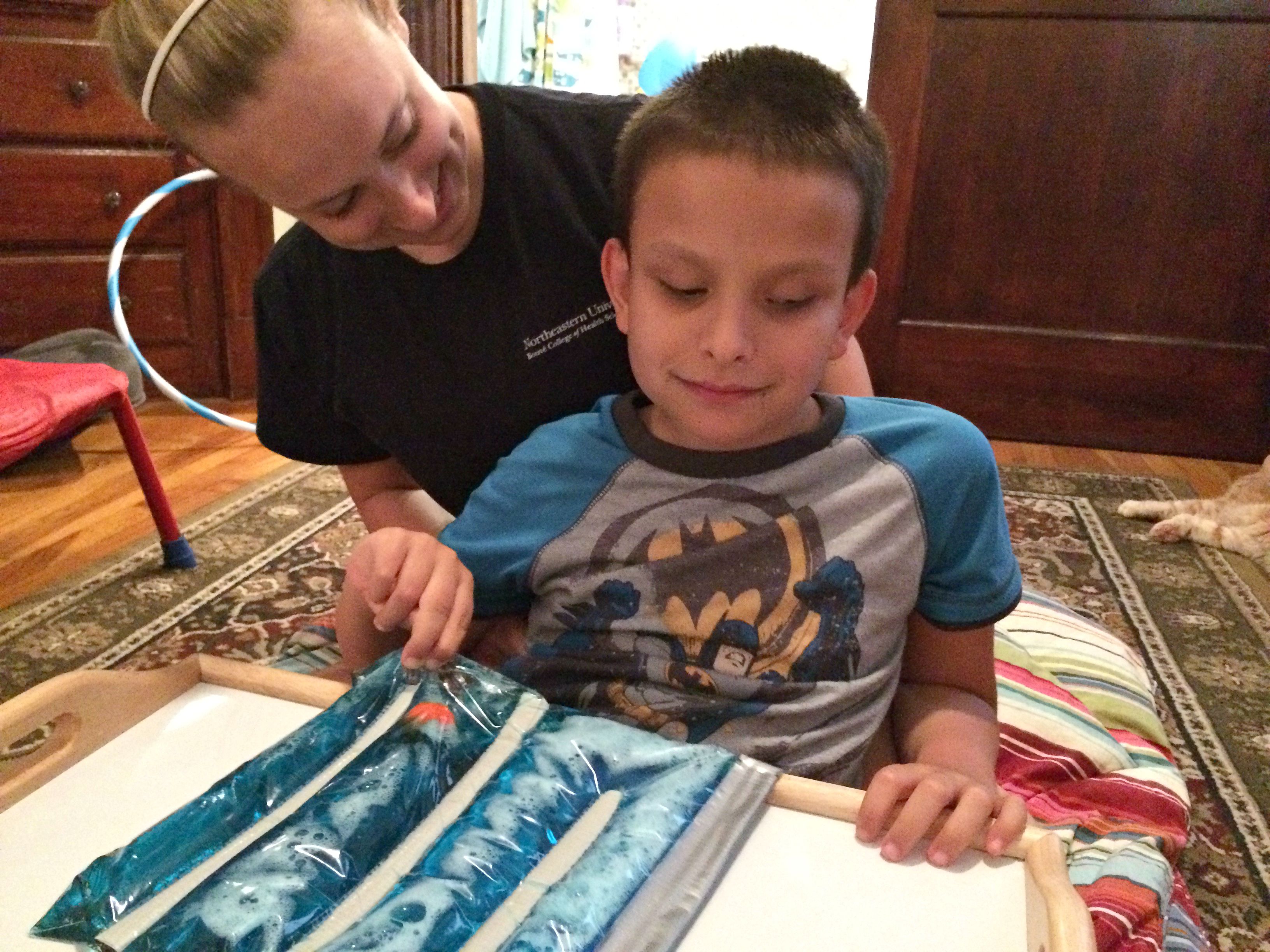 Woman and bind boy play with the Ziploc squish maze.