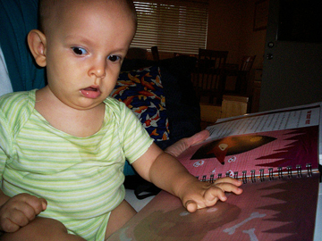 Baby boy feels braille with one hand