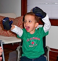 Boy plays with mittens while reading Good Night Moon.